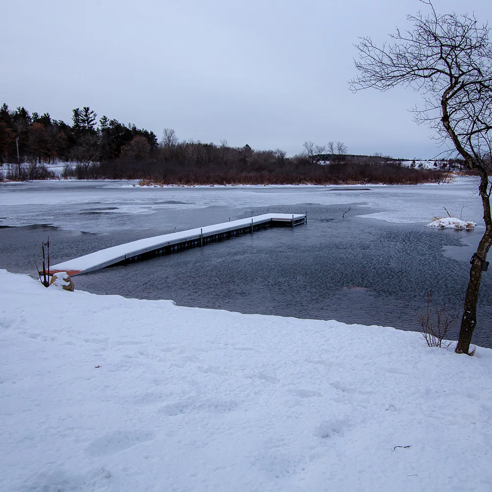 A real residential dock with an open-water pocket in a frozen pond